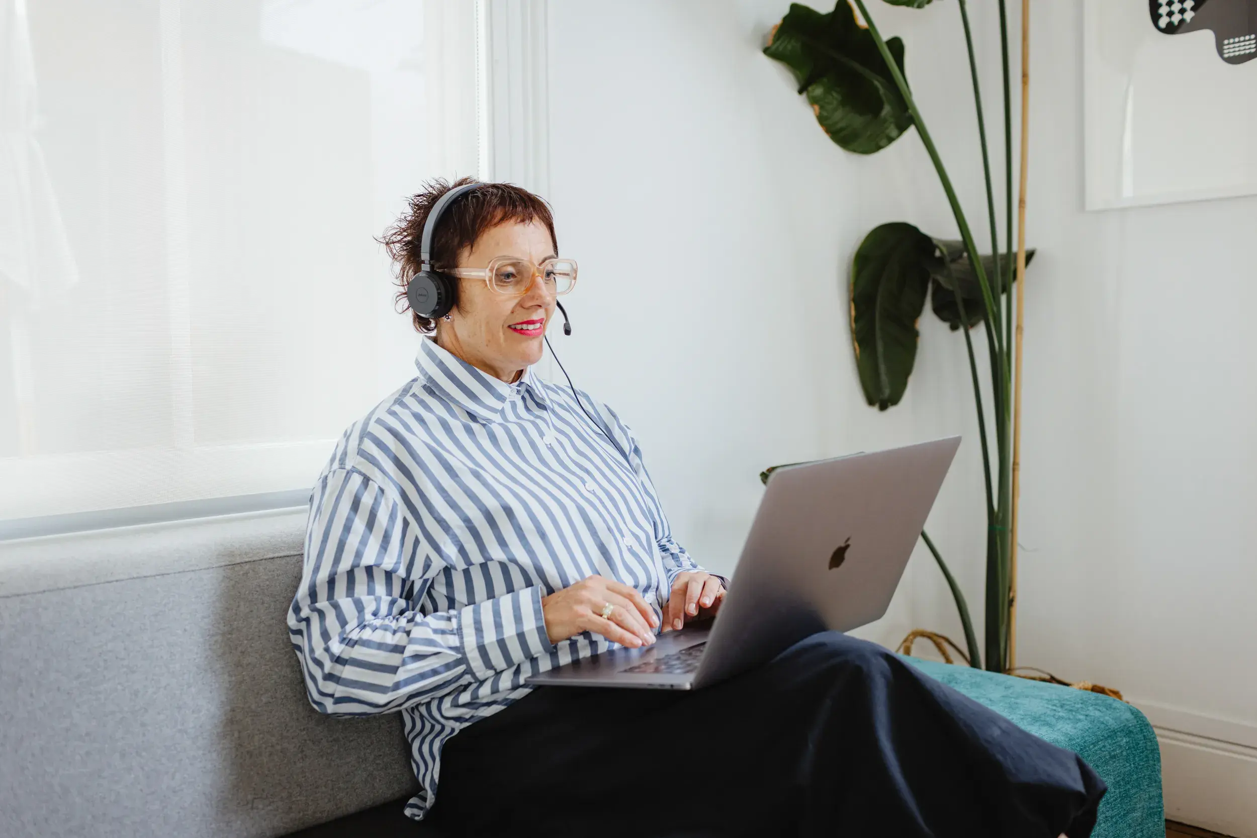 Fully managed Wi-Fi with Wireless as a Service (WaaS) A woman with short hair and glasses, wearing a striped shirt, sits on a sofa with a laptop on her lap, using a headset. Now offers fast, secure wireless connectivity, enabling you to focus on your business while they manage your Wi-Fi needs.