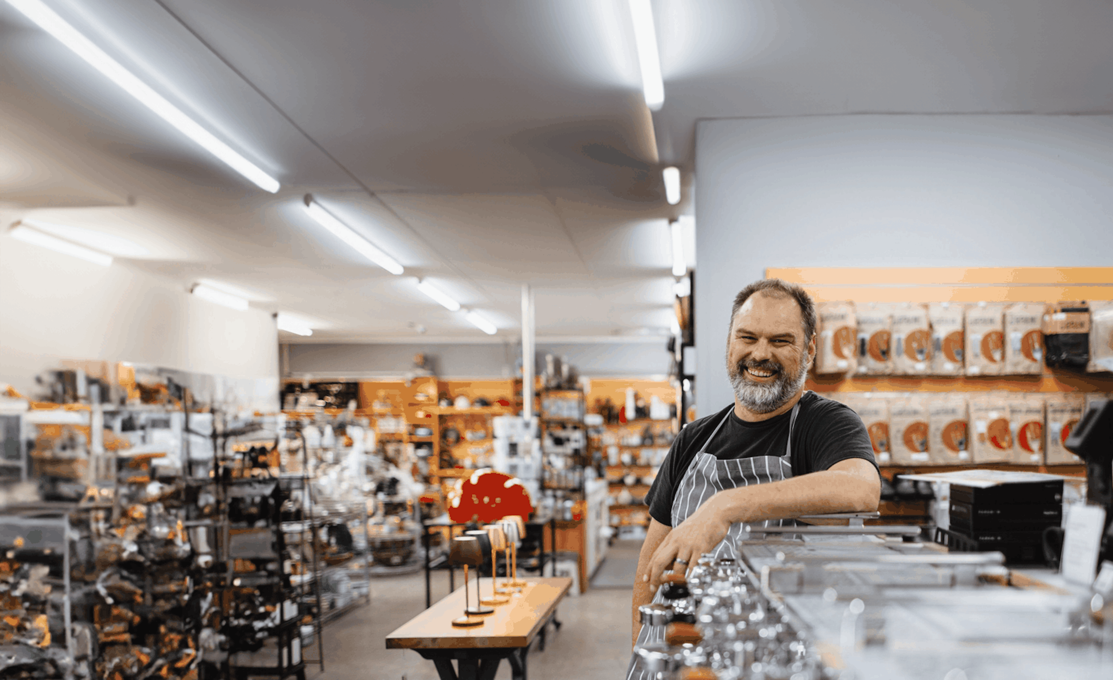 Smiling small business owner in a hardware store, showcasing Now NZ's reliable business broadband and phone solutions backed by local expertise.