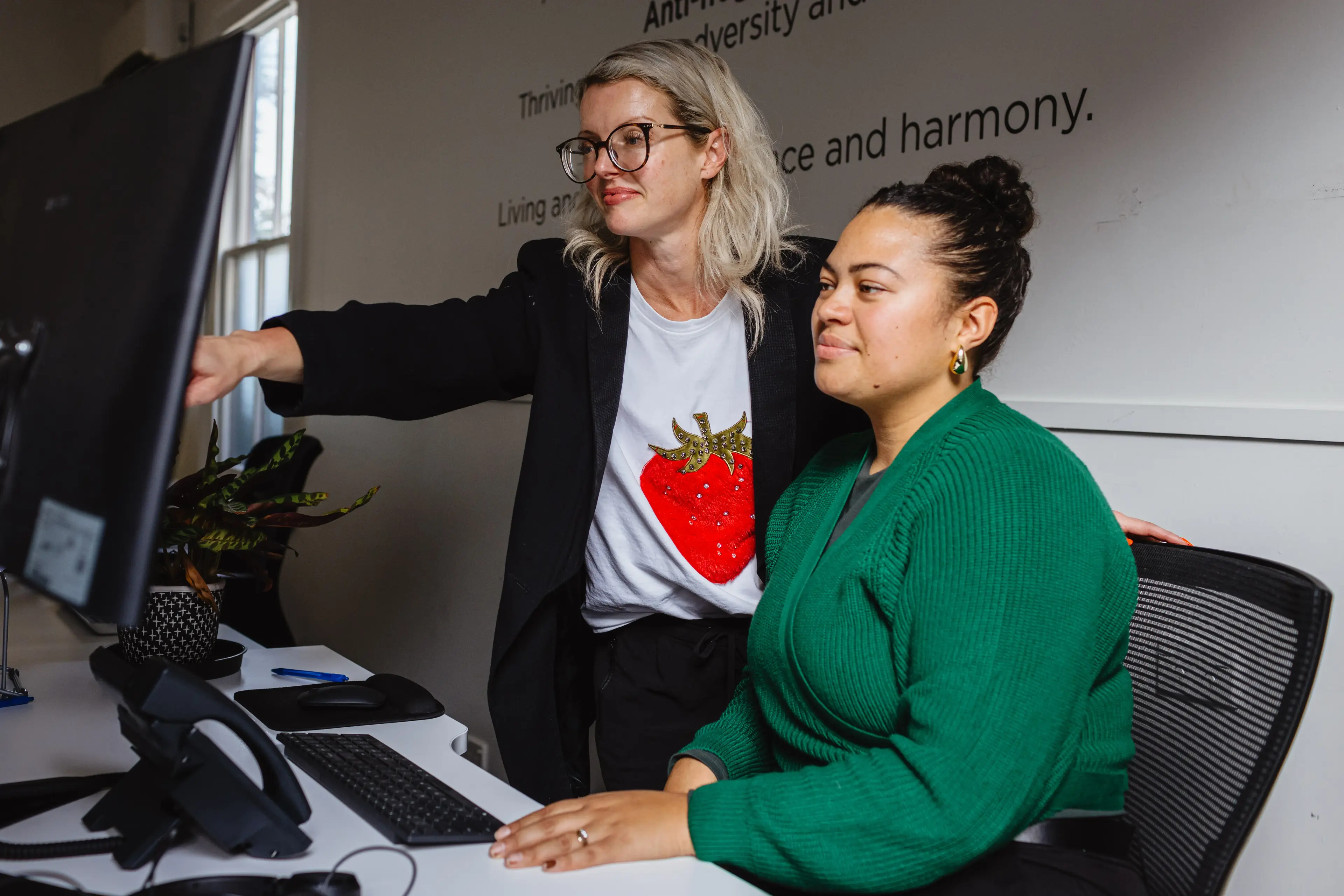 Two professionals collaborating at a computer, highlighting Now's partnerships with industry groups and IT specialists to deliver business solutions in New Zealand.