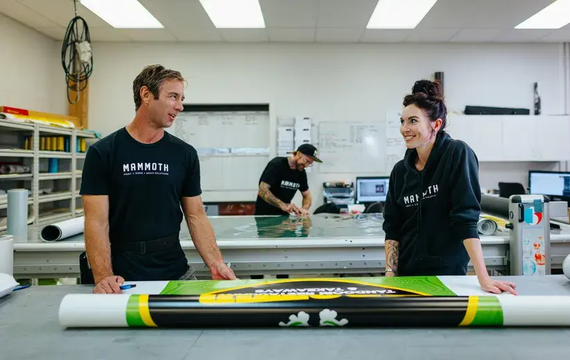 Team of designers in a print shop discussing a project, highlighting Now NZ's reliable high-speed network that ensures uninterrupted business operations.